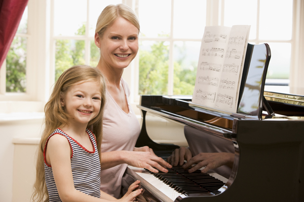 mom and little girl playing piano